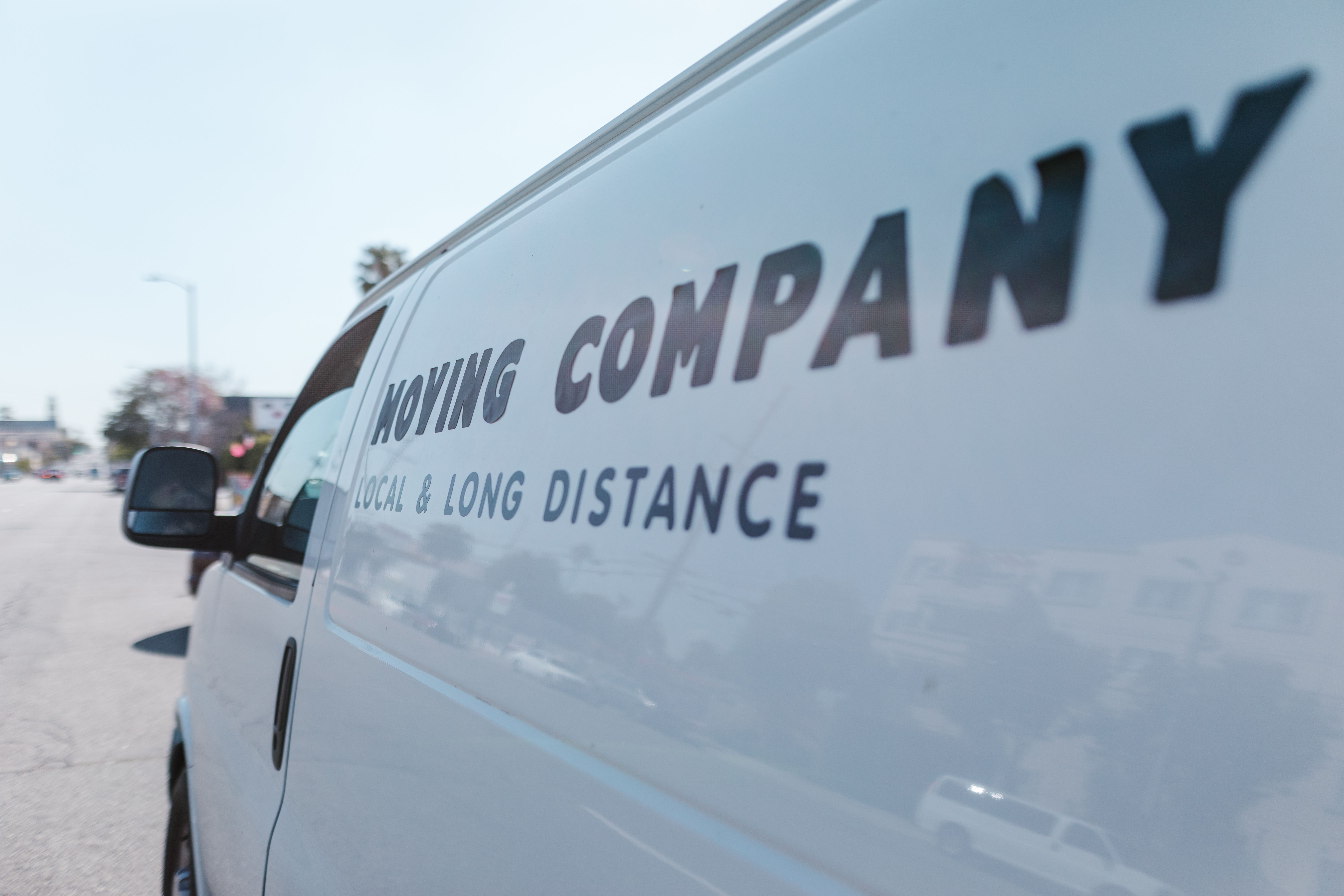White van with black text reading Moving Company Local & Long Distance on the side.