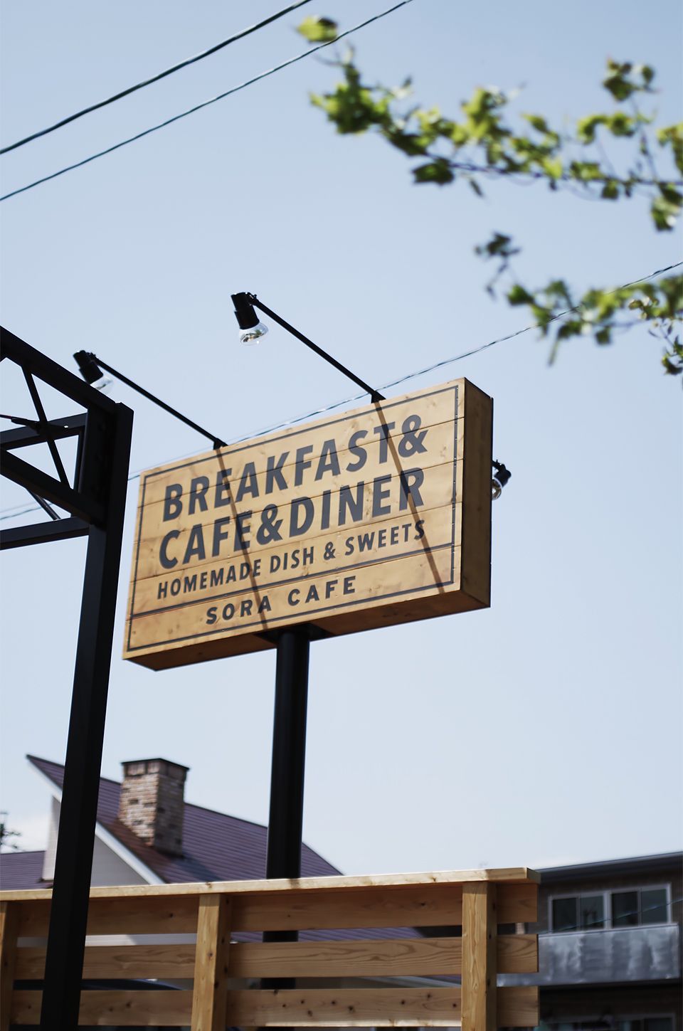 Wooden sign for Sora Cafe offering breakfast, cafe, diner, homemade dishes, and sweets.