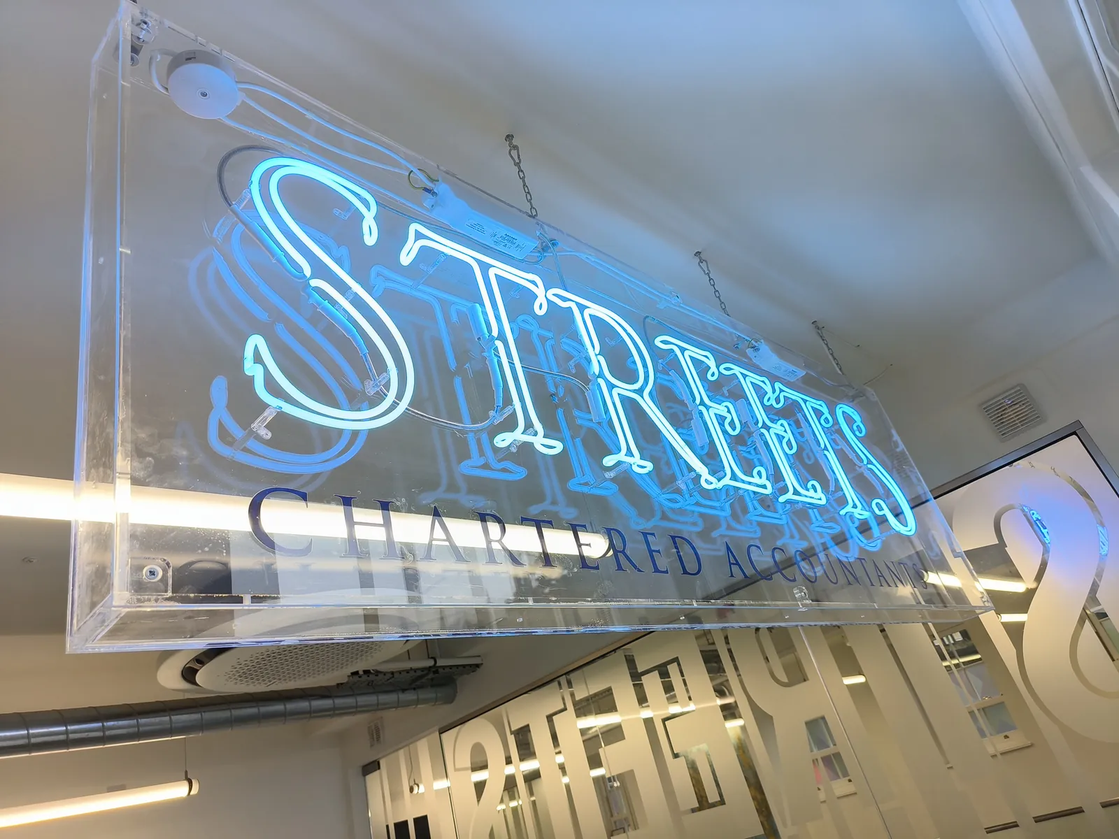 Blue Streets neon sign on a clear acrylic panel