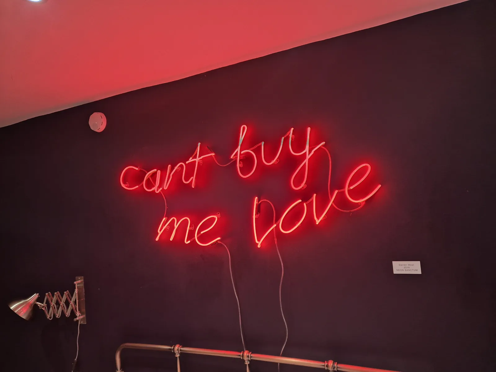 Red neon script sign on a dark wall