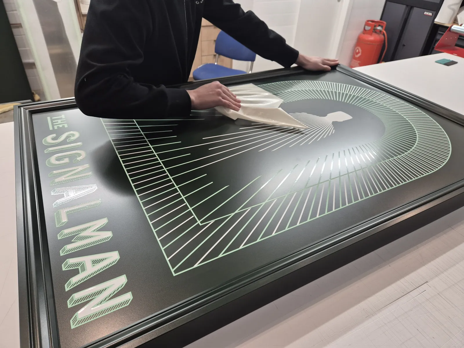 Finishing a printed sign panel in the Odysea Signs workshop