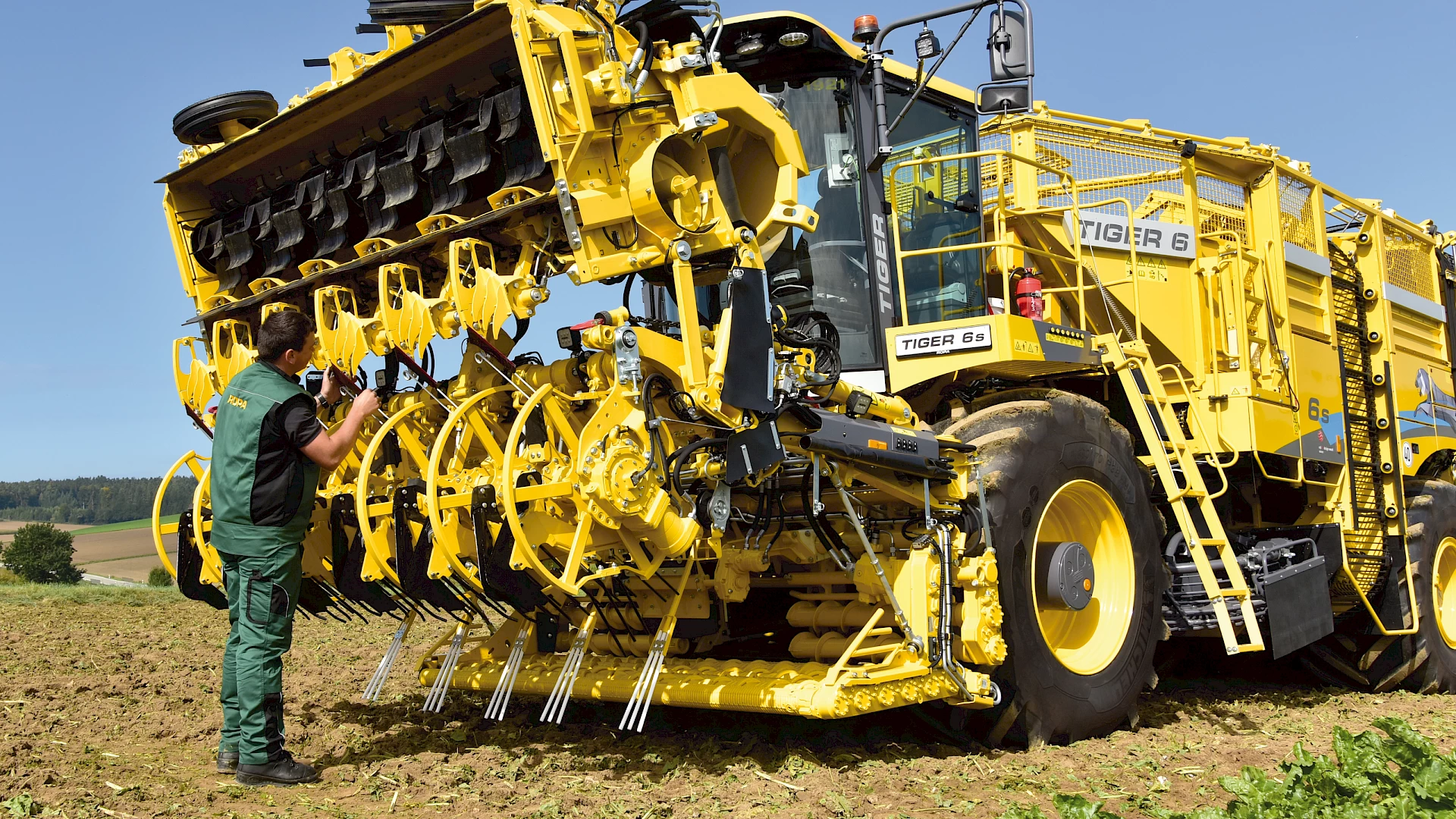 An operator examining the scalping knife on a head of a ROPA Tiger 6S that has been folded into maintenance position