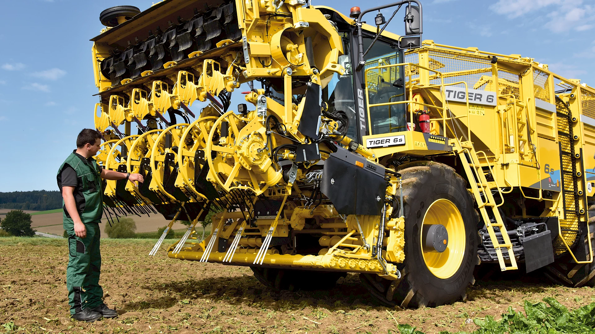 An operator viewing the digging shares on a head of a Tiger 6S that has been folded into maintenance position