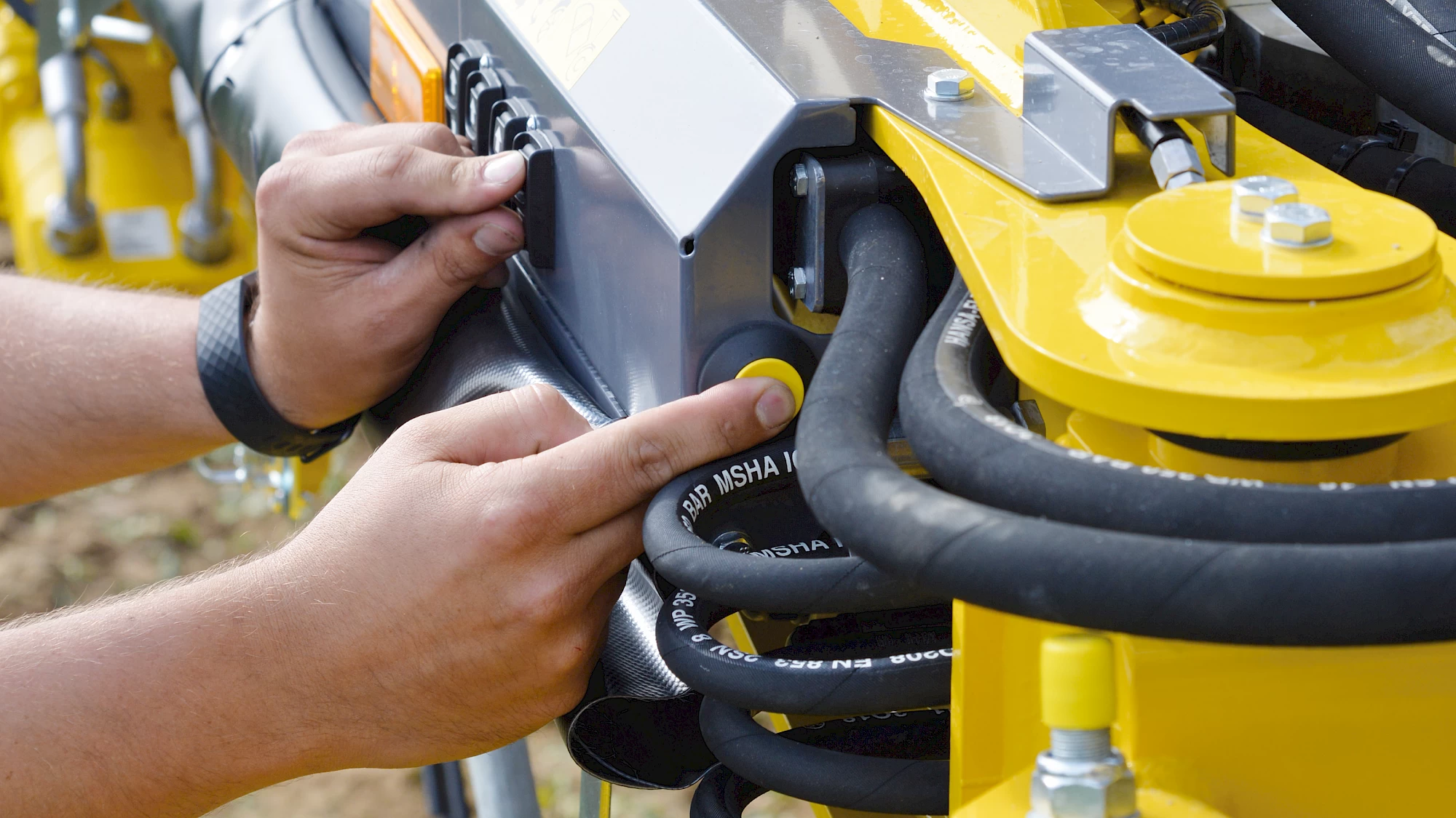 An operator pushing the control buttons on the head of the Tiger 6S to start the engine of the machine