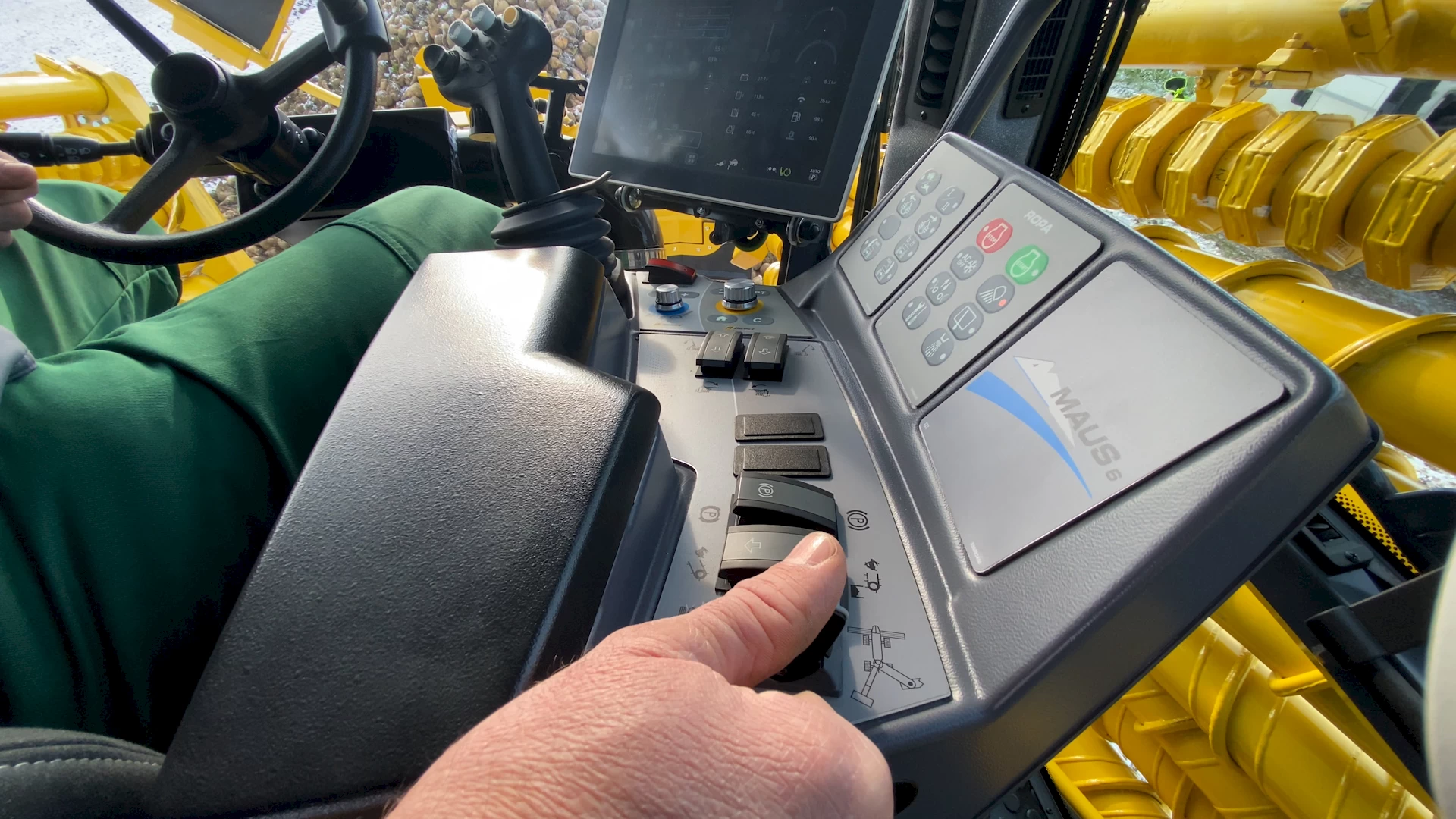 An operator pushing the toggle to automatically unfold the ROPA Maus 6 from transport position to field position