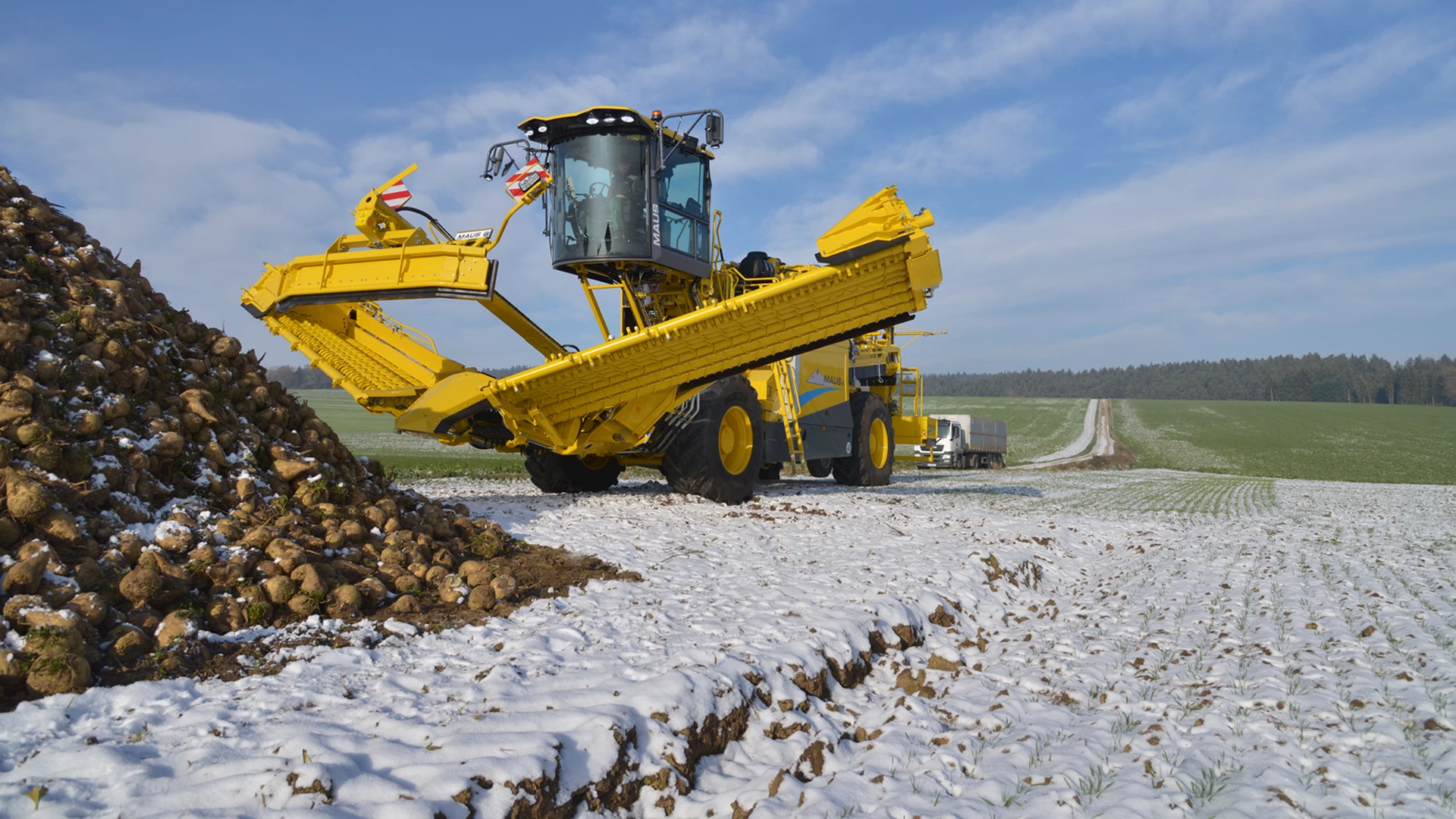A ROPA Maus 6 partially unfolded in a field with snow on the ground and a sugar beet field pile