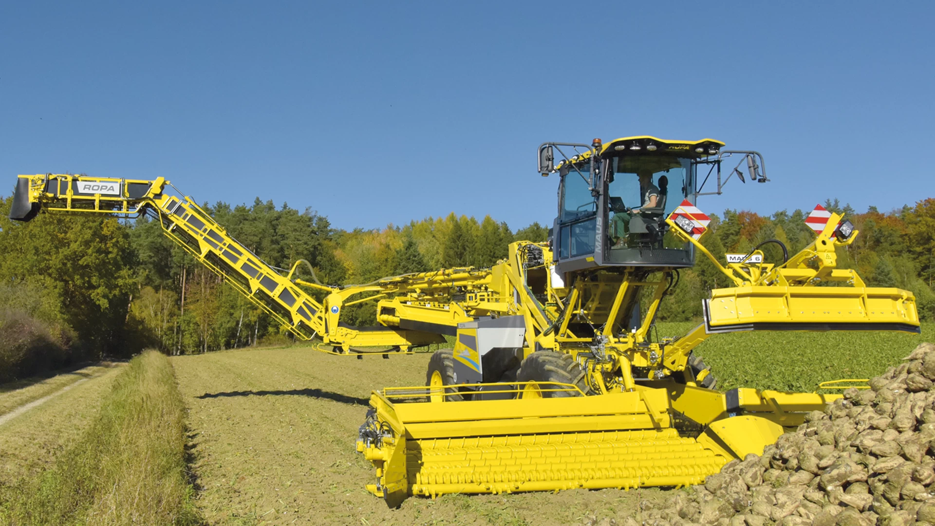 The ROPA Maus 6 fully unfolded in front of a field pile of sugar beets. Step 7/7 of the automated unfolding process.