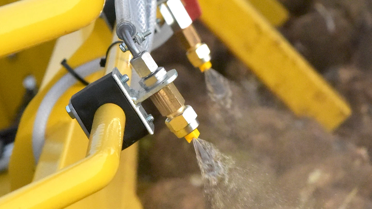 A close-up image of the water spray system nozzles spraying water on the pickup head of the ROPA Maus 6