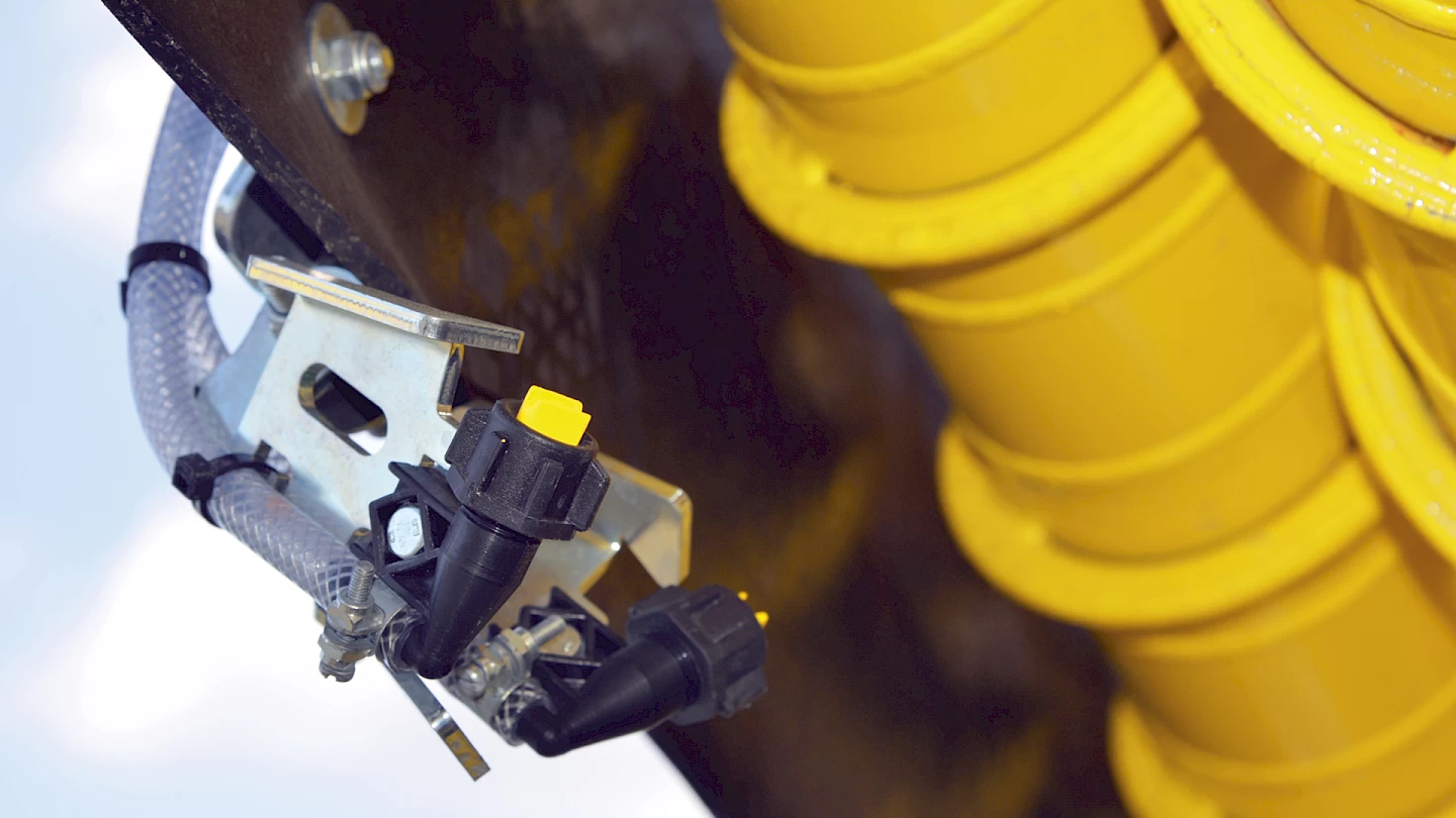 A close-up of the water-spray system nozzles located on the underside of the recleaner on the Maus 6