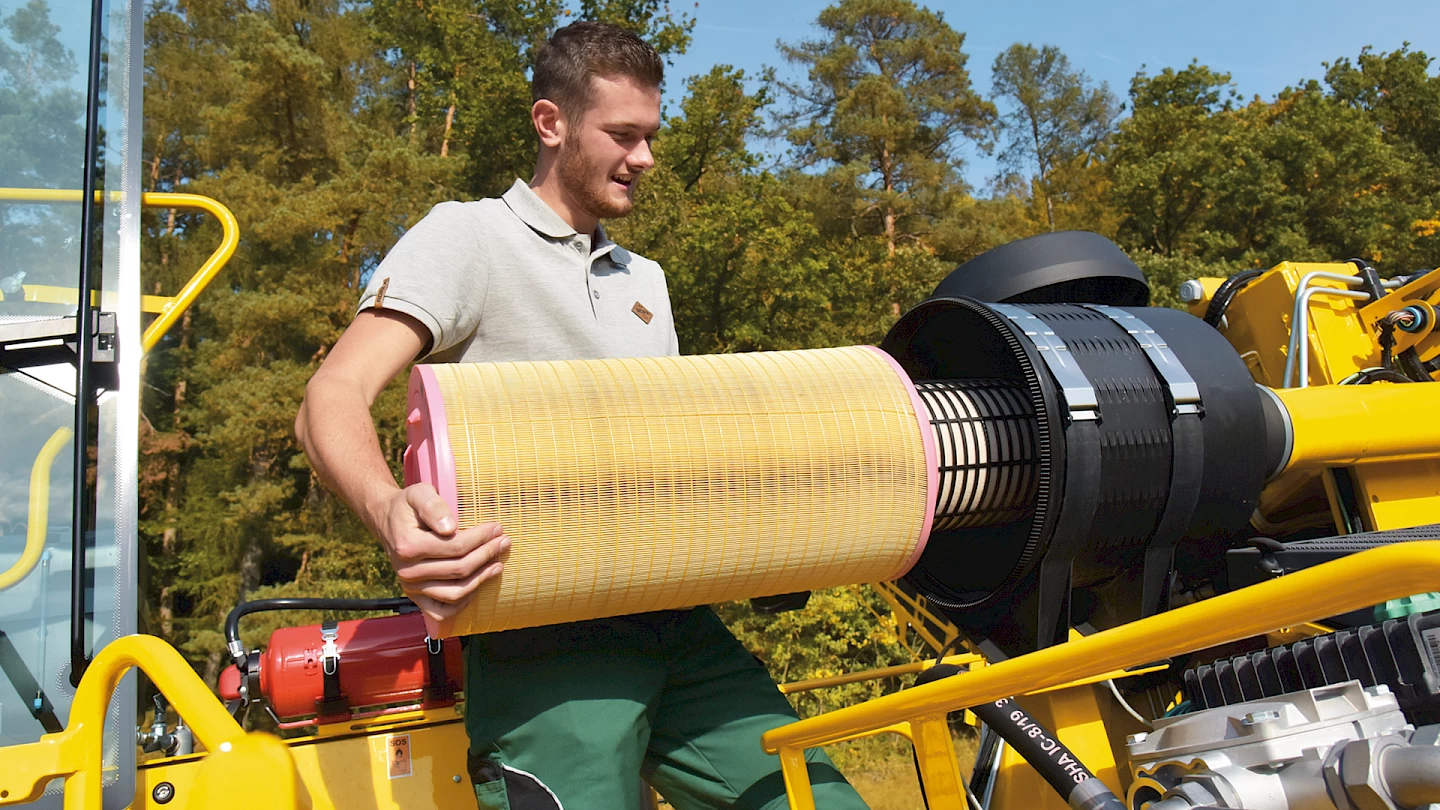 An operator removing the engine air filter on the Maus 6