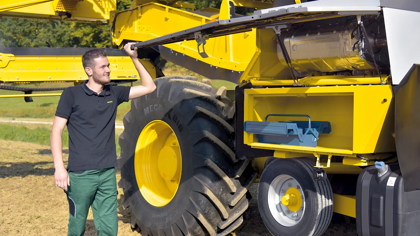 An operator opening the side engine panel on the ROPA Maus 6