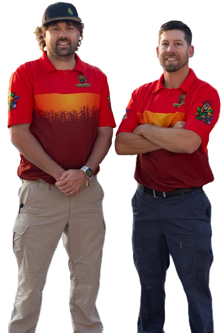 Two men wearing red and orange Cornwell Plumbing shirts and cargo pants, standing side by side, one with arms crossed.