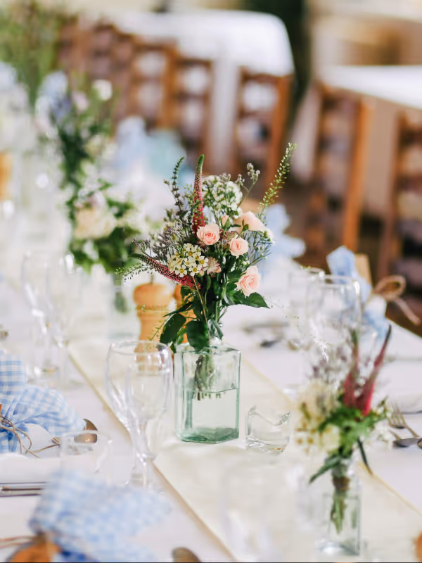 Bröllopsfest med dukat bord och blommor inför middag och fest