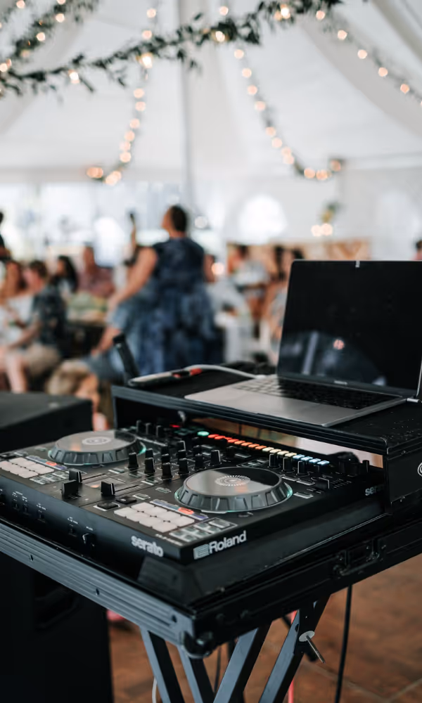 DJ-utrustning med mixer och laptop under pågående fest