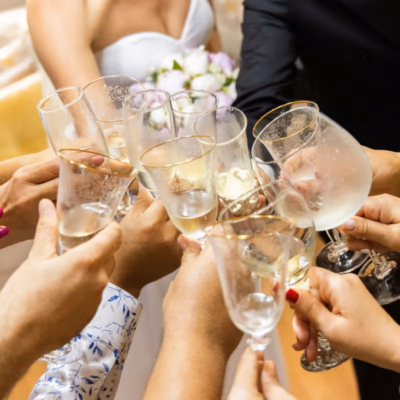 Gäster som skålar i champagne under bröllopsfirande med varm och stämningsfull belysning