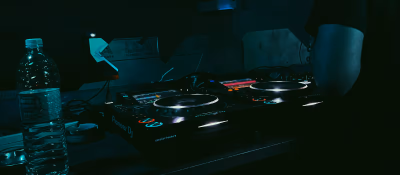 DJ som spelar musik i ett mörkt rum med stämningsfull belysning