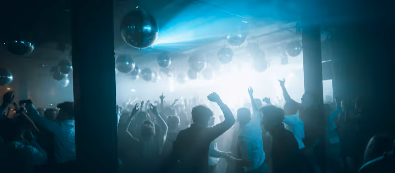 Festlig stämning på ett dansgolv med partybelysning och DJ