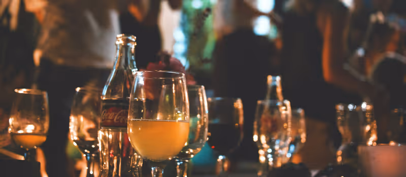 Halvfulla glas med dricka under en fest med glada gäster