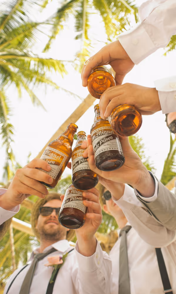 Folk som skålar med glasflaskor under en sommarfest