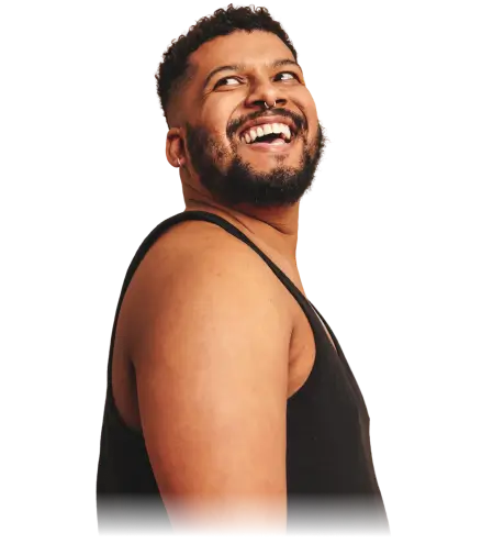 Smiling man with beard and mustache wearing a black tank top looking upwards.