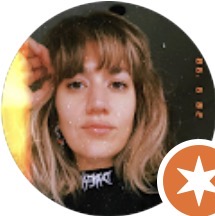 Retrato circular de una mujer joven con cabello castaño y flequillo, con expresión neutra y luz cálida a la izquierda.