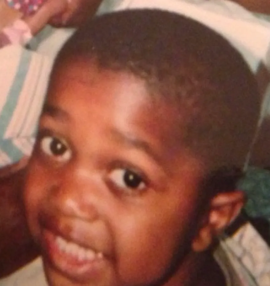 Close-up portrait of a young child with wide eyes and a surprised expression looking toward camera.