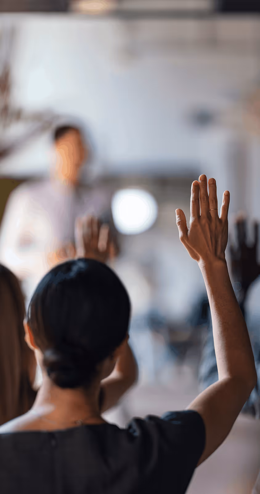 Hands raised in classroom.