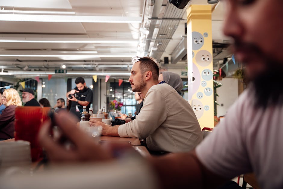A diverse group of people engaged in a lively meeting at a modern London workspace, with a focus on collaboration.