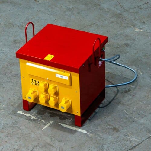 Portable yellow and red electrical transformer box with multiple outlets labeled 110 volts on a concrete surface.