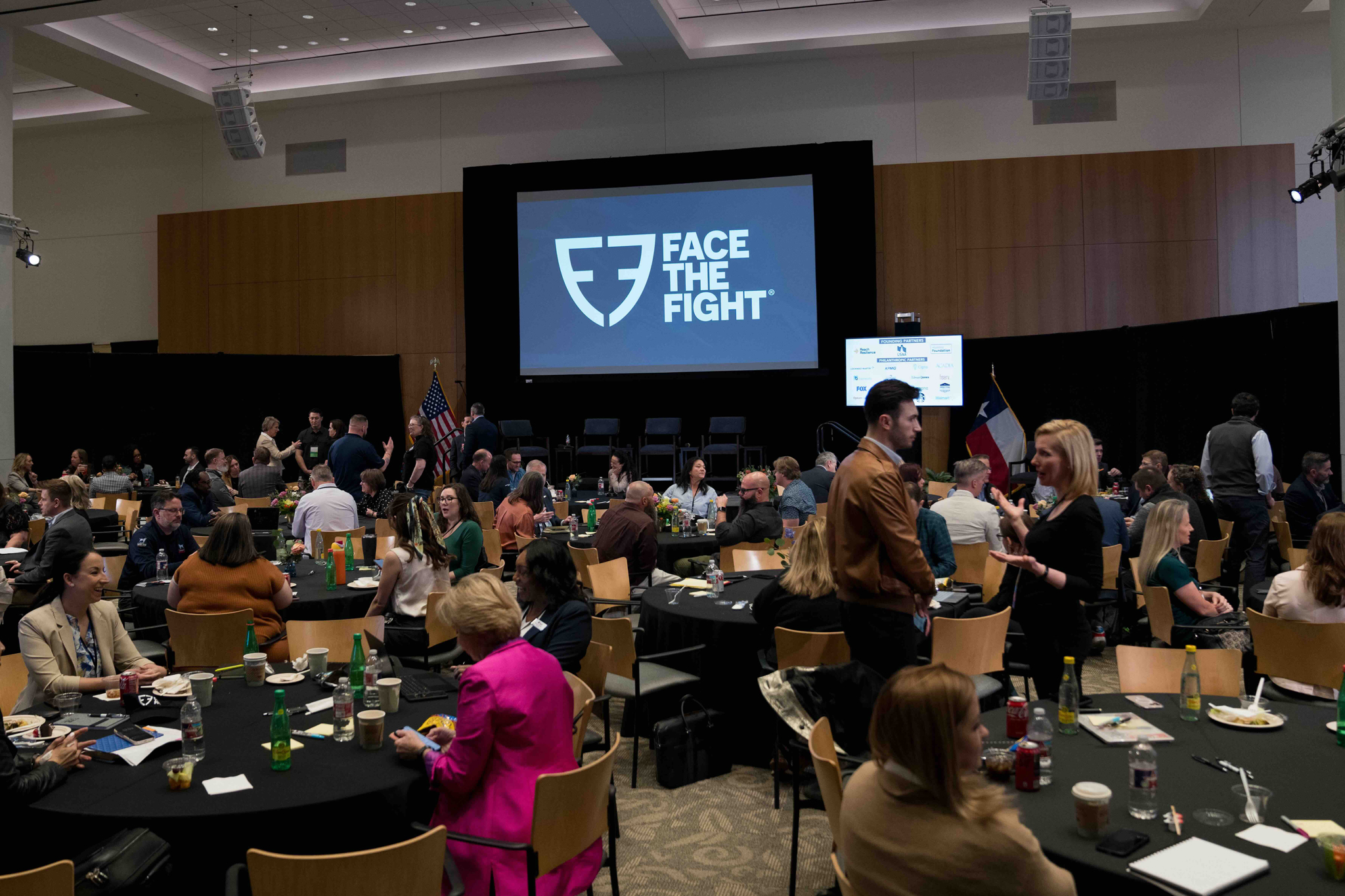 A ballroom full of members gathered around tables for a Face the Fight Coalition Meeting.