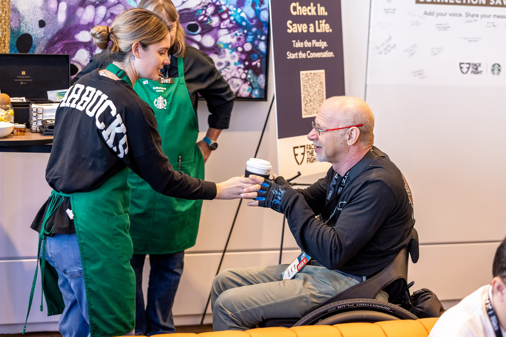 A Starbucks employee serving a drink to a veteran at the MIC Conference in Atlanta.
