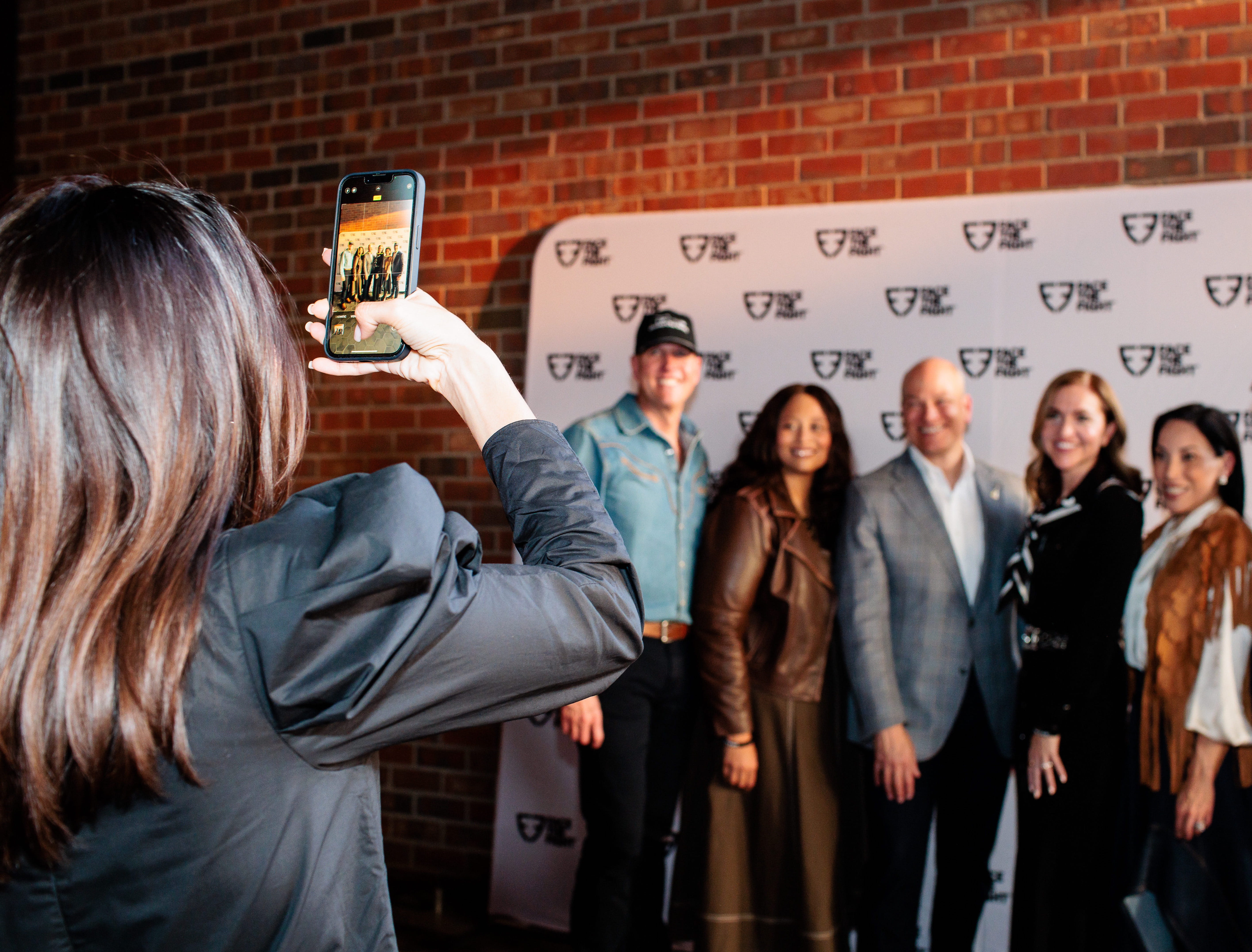 A person taking a group photo on a smartphone of the Face the Fight leadership team.