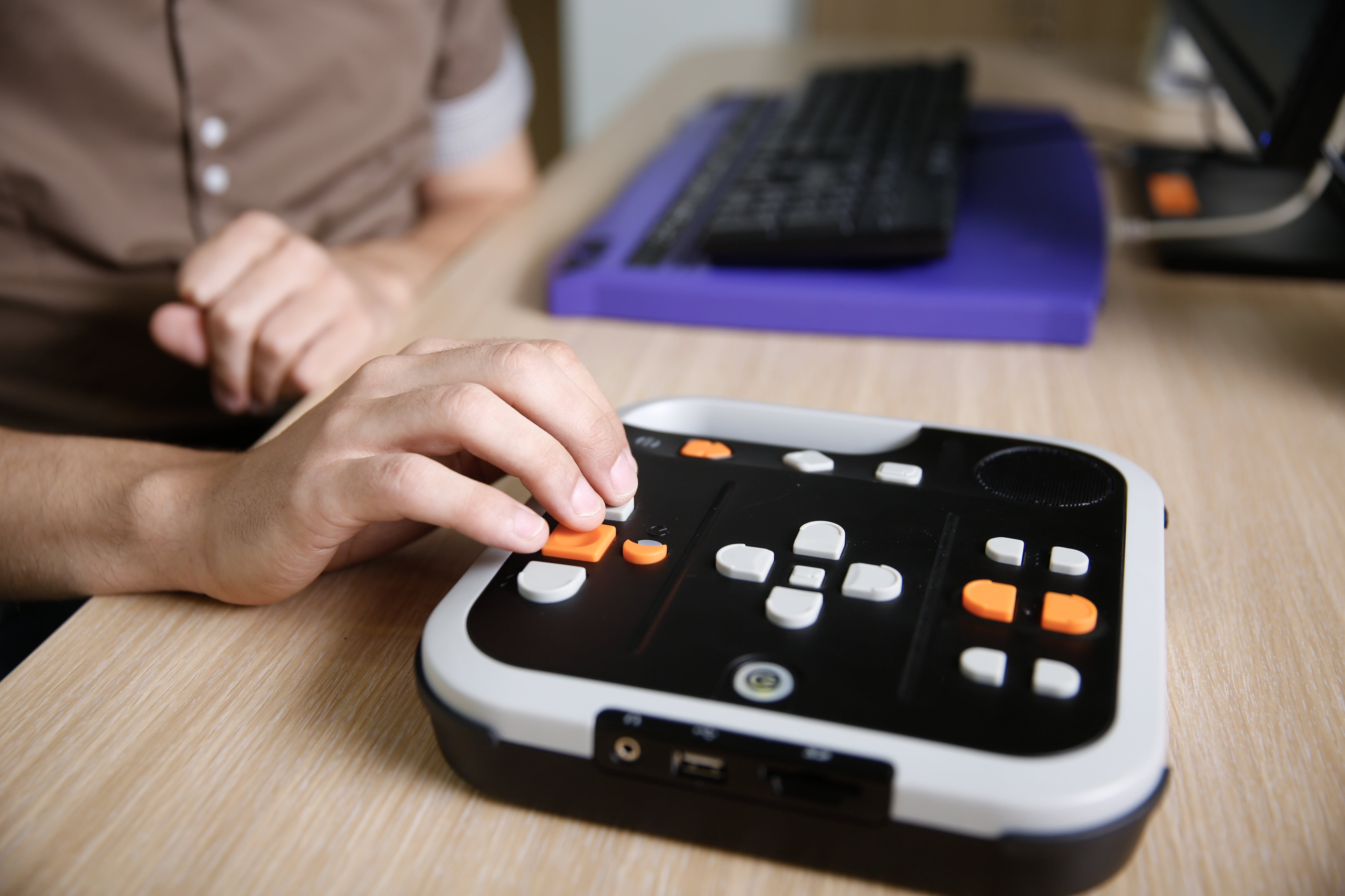A closeup of someone using an accessibility device on a computer desk.  