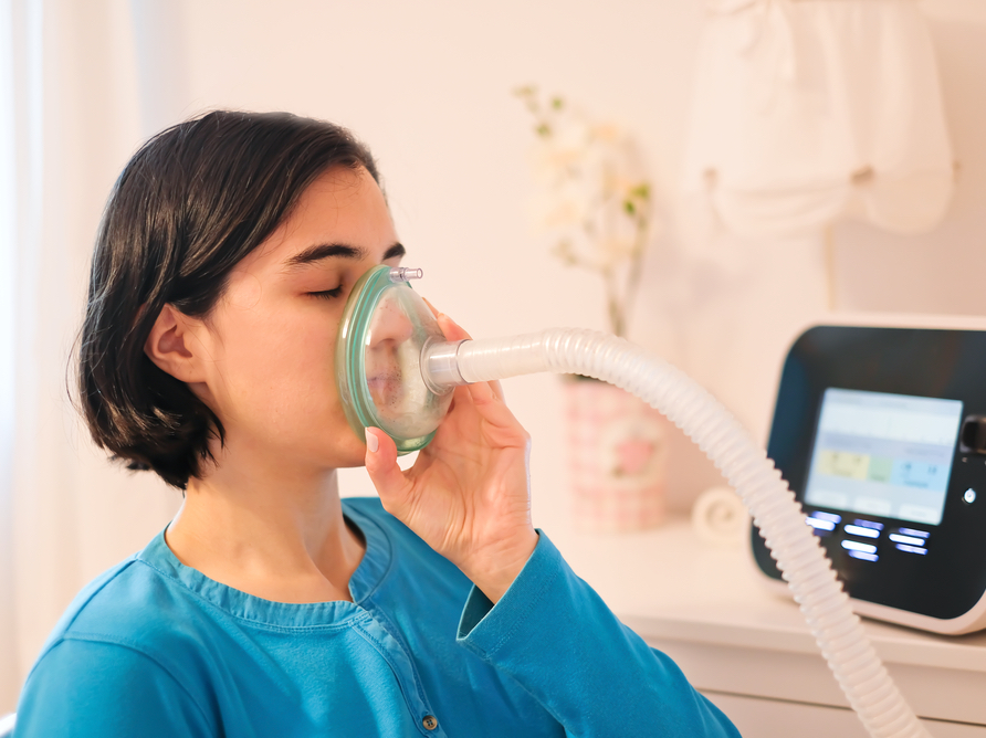 A photo of a woman using an oxygen mask
