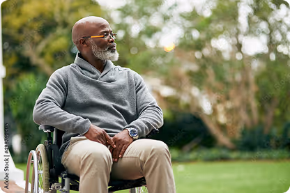 Elderly man, sitting in his wheelchair in a park.