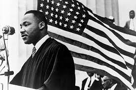 Black and White Image of Martin Luther King Jr. with a US Flag flying behind him