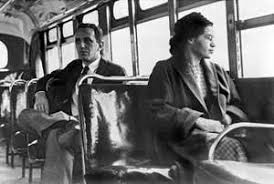 Image of 1960s era bus with an African American woman Rosa Parks) wearing glasses looking out of a bus window