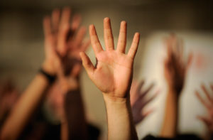 image of raised hands in a classroom