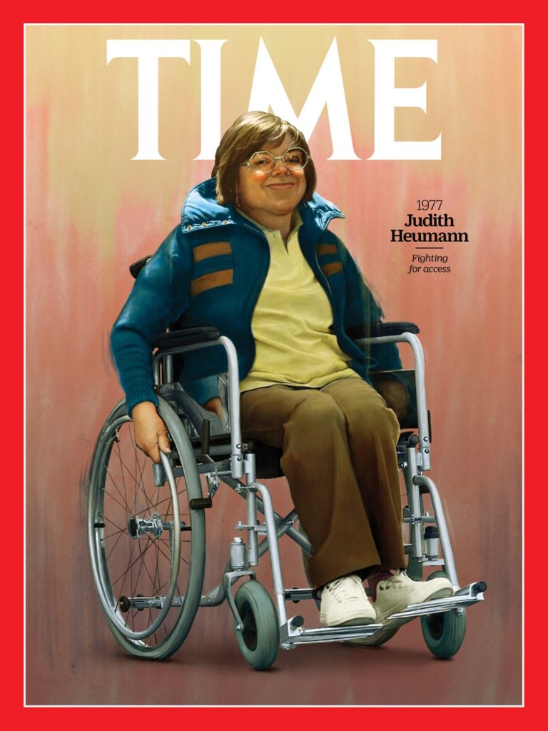 Image of 1970s era Judy Heumann in her wheelchair waearing khakis sneakers a yellow sirt and tranck jacket and her trademark glasses from the time — under the Time Masthead with the words 1977 Judith Heamann fighting for access