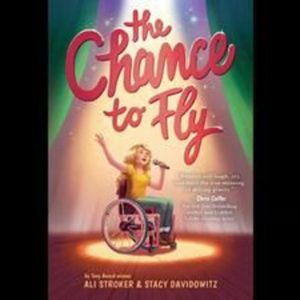Long Description Book cover of a woman in a wheelchair under a spotlight and holding a microphone. The Title in Pink Cursive text reads, “The Chance to Fly”