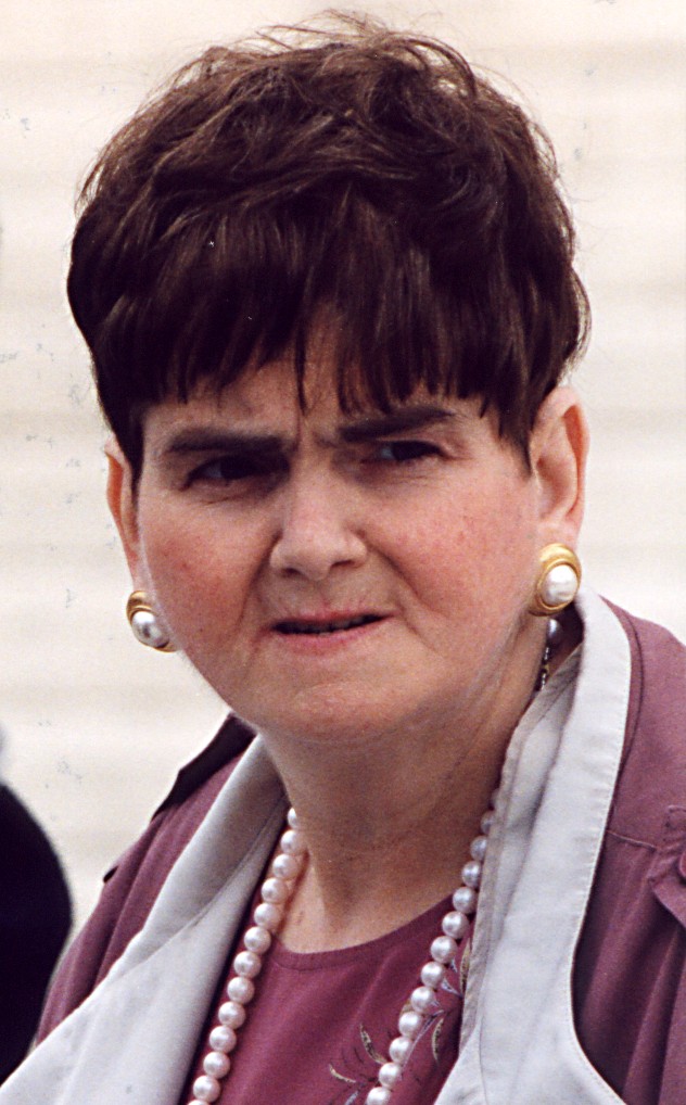 Image of woman wearing pearls and a red shirt