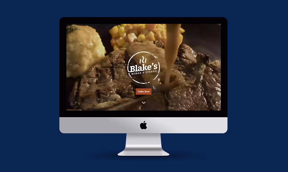 A Macintosh mockup showing Blake's Wings and Things website with a background picture of a steak.