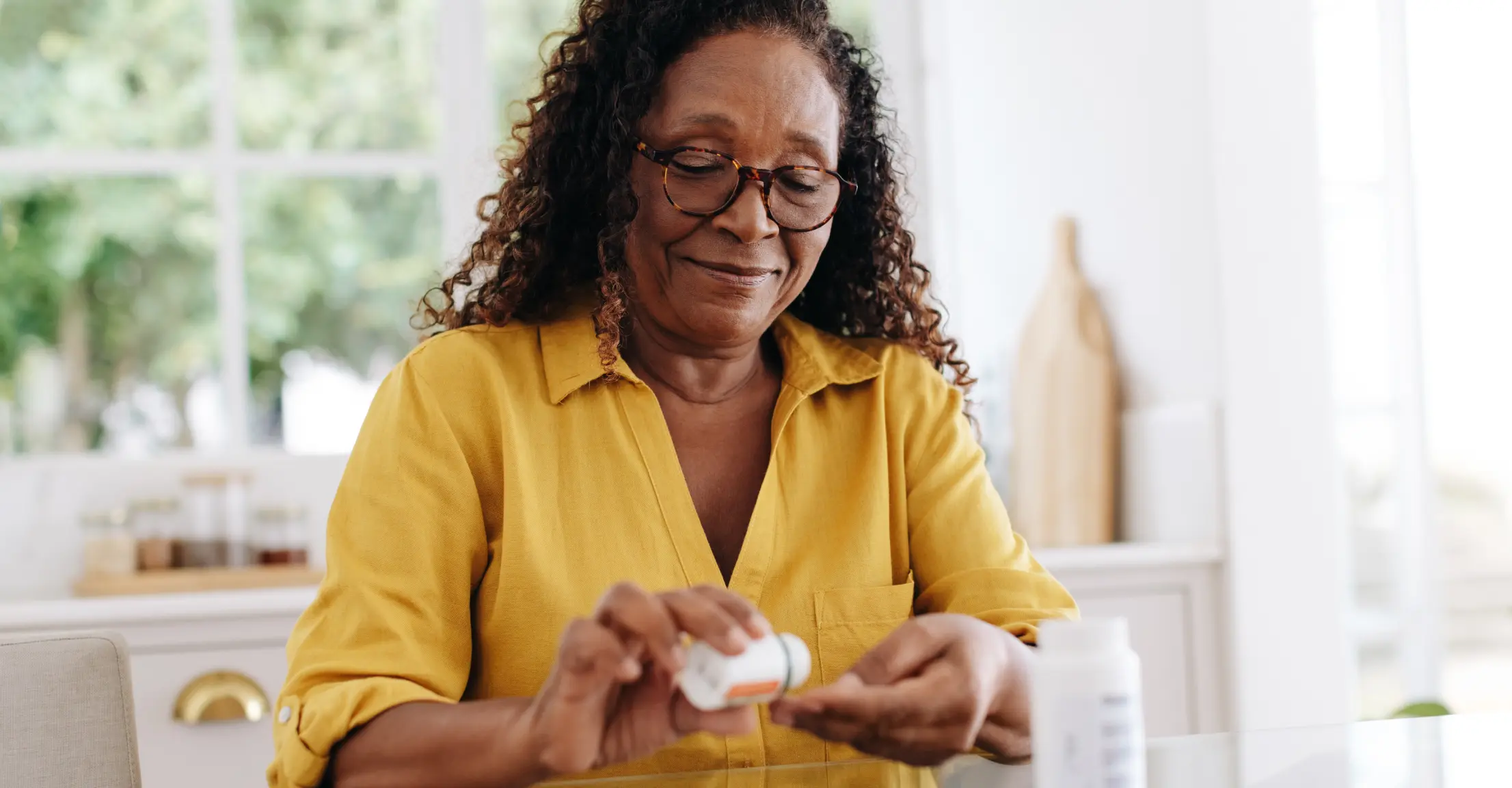Woman taking pills out of bottle