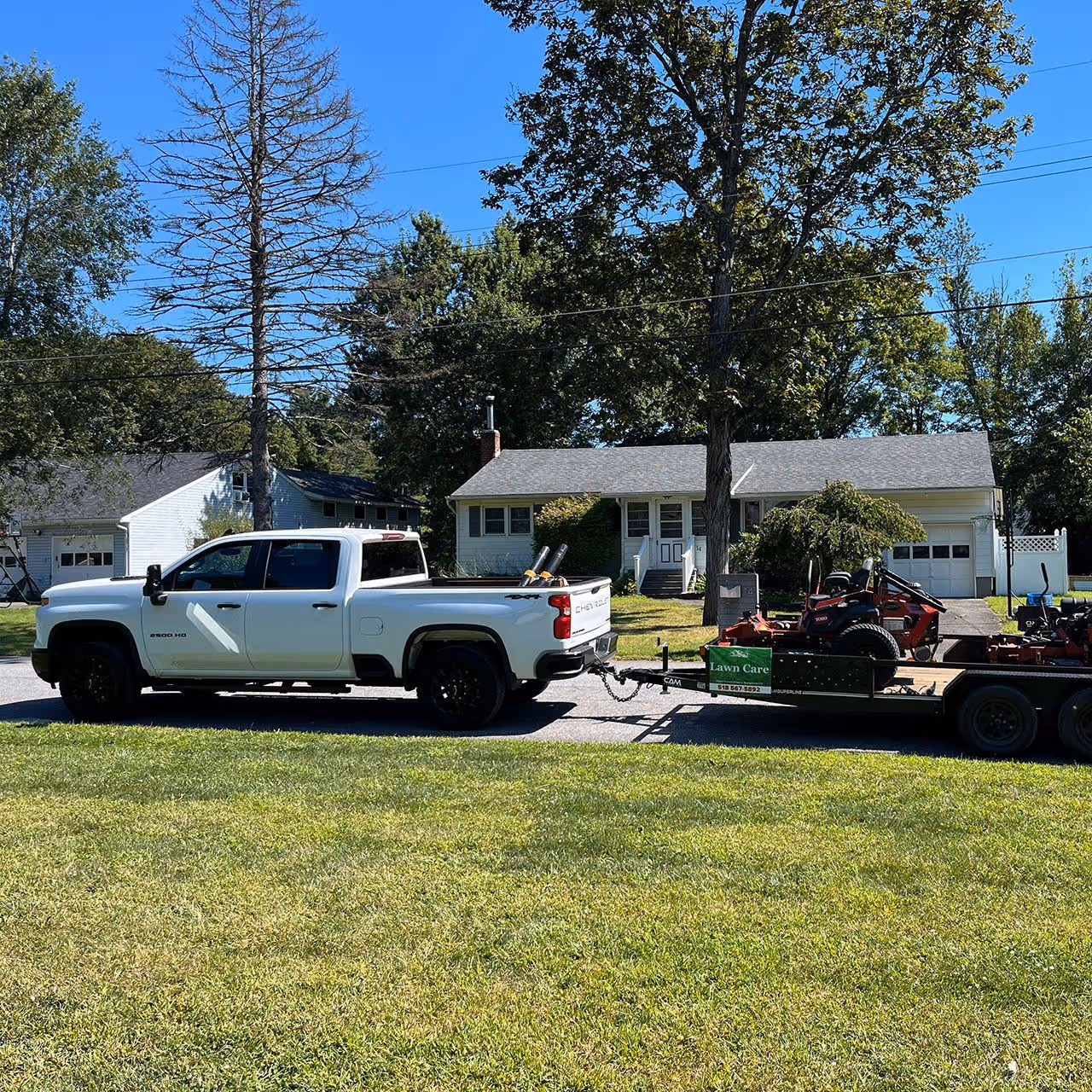 Branded truck and landscaping trailer from Higher Ground Property Management LLC on site for property maintenance in Rhinebeck NY