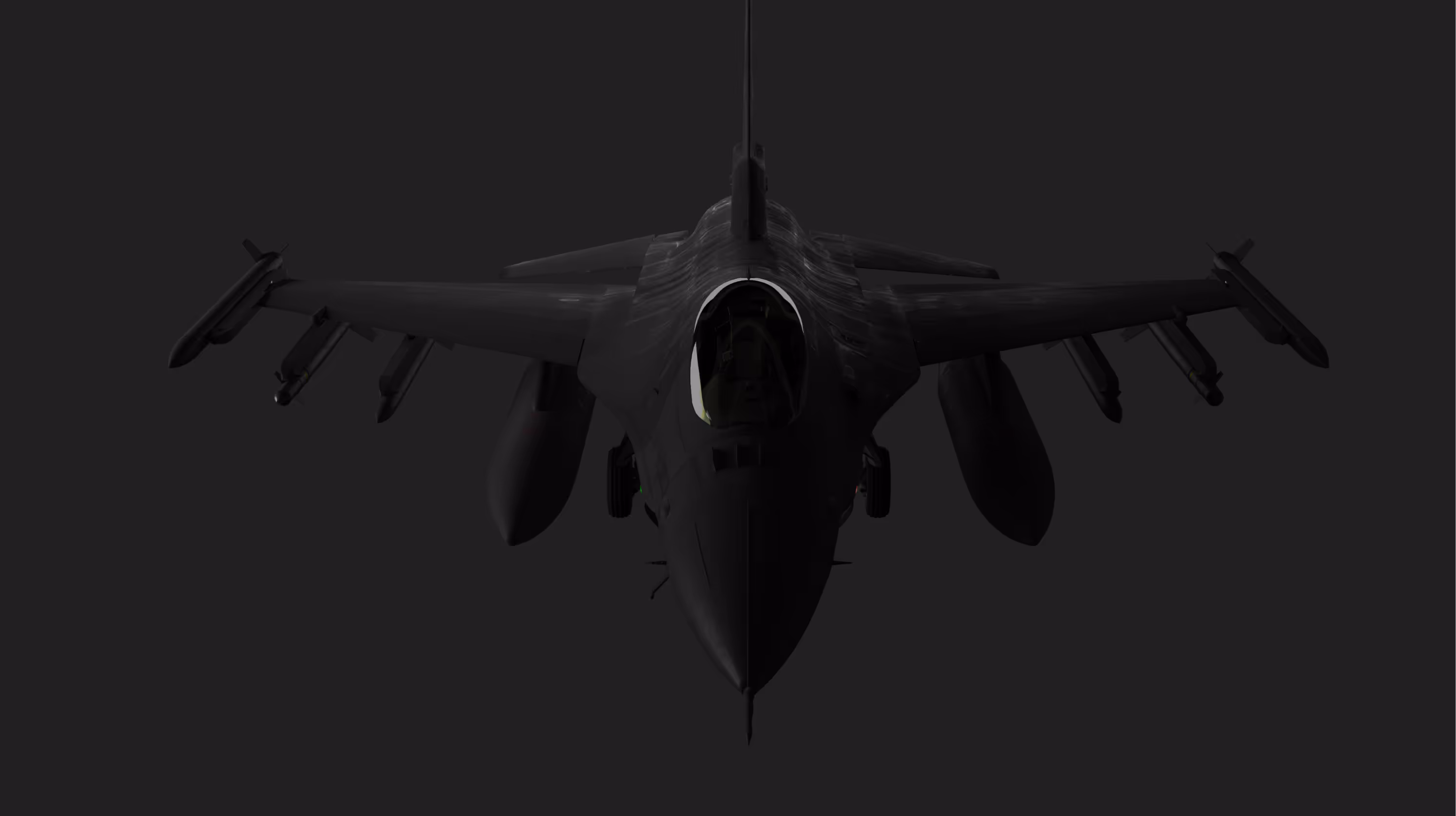 Front view of a dark military fighter jet with missiles under its wings against a black background.