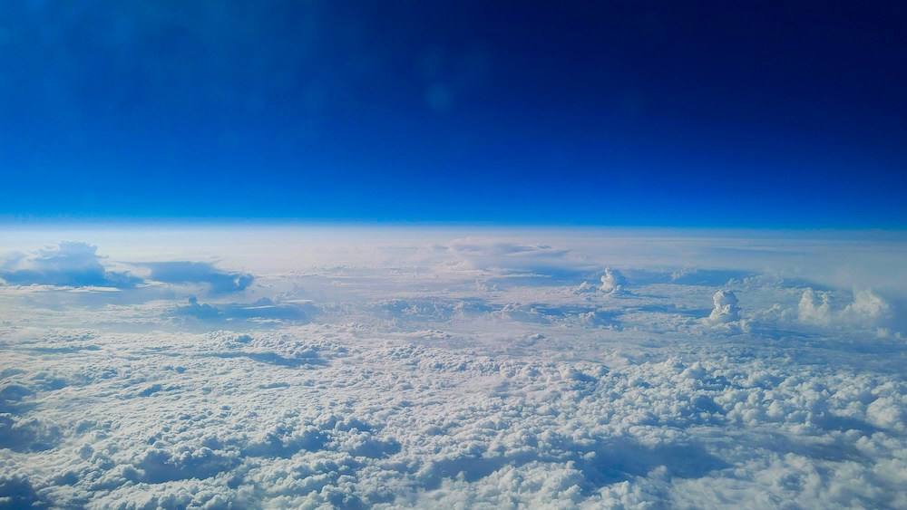 View of a dense cloud layer under a deep blue sky from a high altitude.