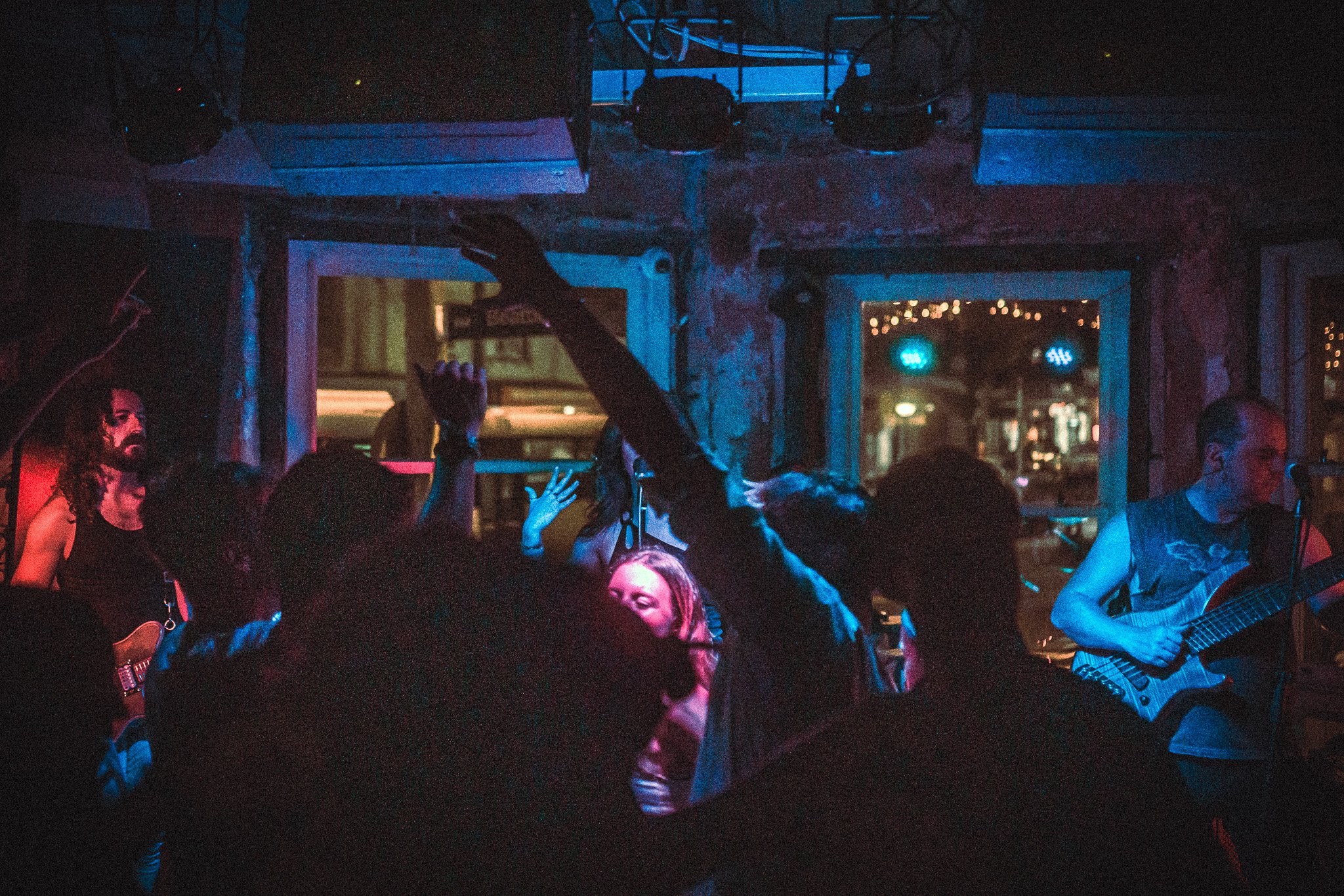 Crowd enjoying LUXE  live music in a dimly lit indoor venue with blue and red lighting.