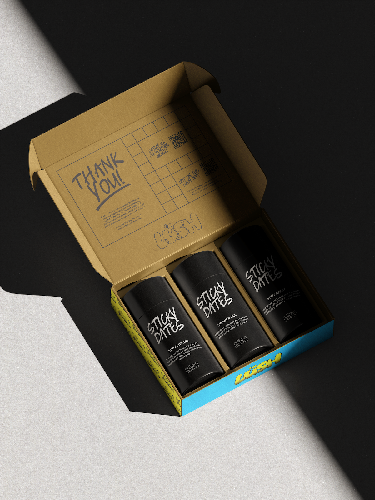 Open gift box with three black Lush Sticky Dates body care bottles inside under spotlight.