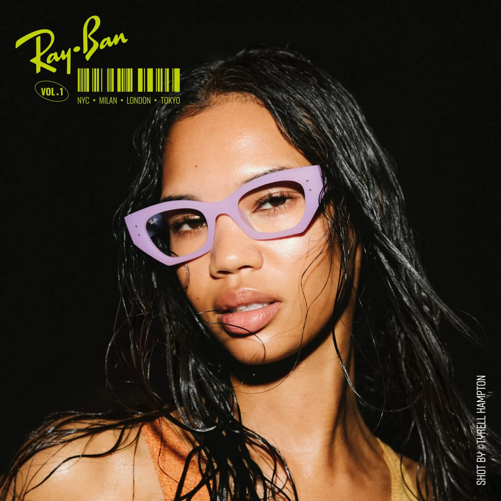 Close-up of a woman with wet hair wearing stylish purple cat-eye Ray-Ban glasses against a black background.