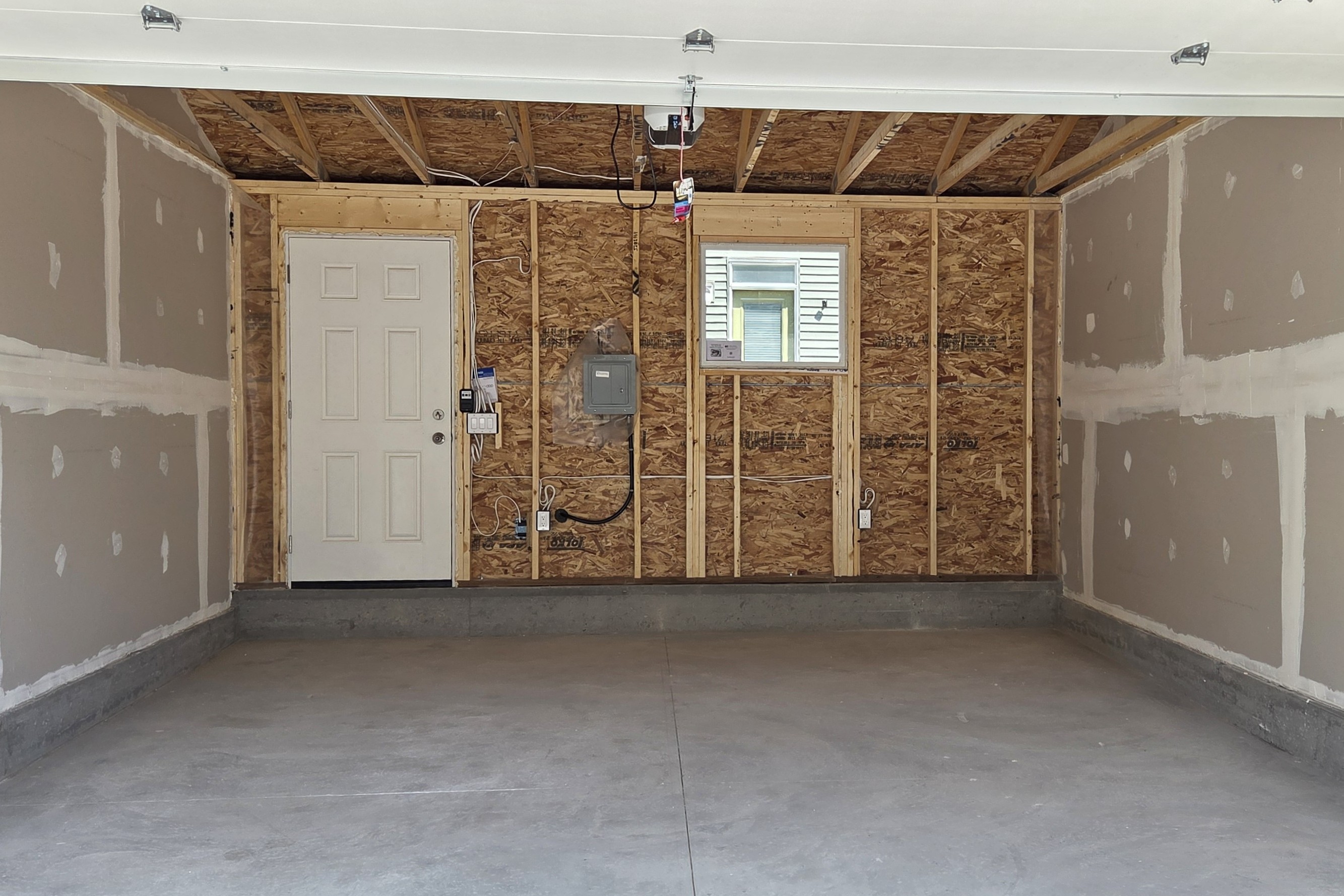 Basement under construction with wooden framing for walls and pink insulation on the exterior walls.